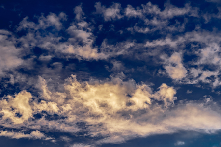 cumulus and cirrus clouds against the evening blue sunset sky, nature seriesの写真素材