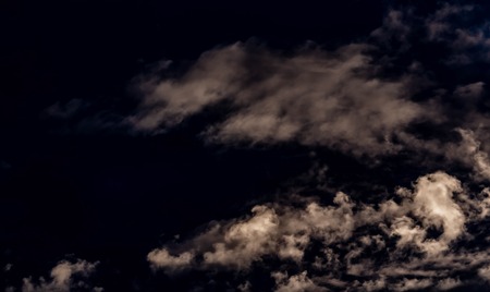 clouds in the shape of faces against the dark evening sky, nature seriesの写真素材