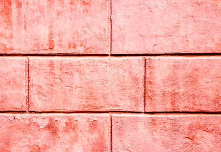 background of tiles in the form of a brick of coral color with traces of peeling paint. Main trend conceptの写真素材