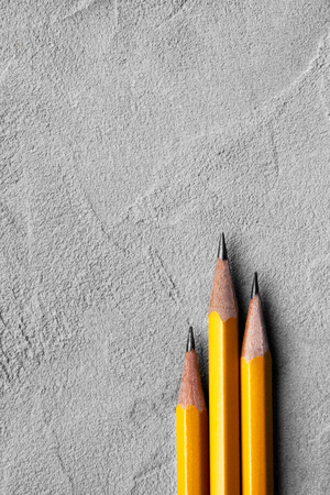 concept of construction, Back to school , three sharpened pencils on a background of gray plaster texture, space for text. concept of business. Creative flat lay with copy spaceの写真素材