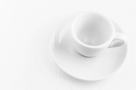closeup top view on white coffee cup and saucer, empty coffee-free coffee cup, for black coffee, on a white background, pastel shades, copy spaceの写真素材