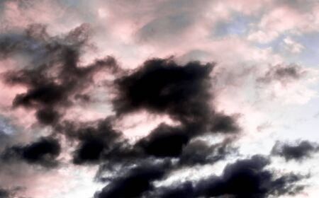 clouds in the shape of faces against the dark evening sky, nature seriesの写真素材
