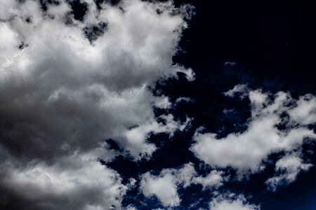 luminous white cloud in the shape against the background of a dark blue sky, sun rays, daylight,...