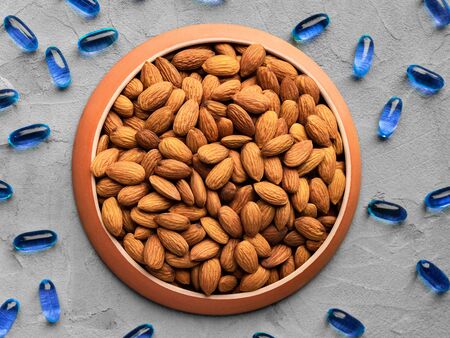 organic food and chemical medicines, biologically active food supplement, almonds and chemical vitamins on a gray background, top view, healthy eating concept, BAAの写真素材