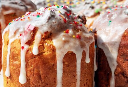 Easter cakes with icing. Glaze flows down white smudges with colorful powders and candy, confetti...