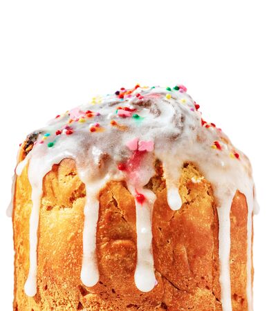 Easter cake with white flowing icing and colored confetti close-up isolated on a white background. The porous structure of baking closeup. Morning baking in the sunshineの写真素材