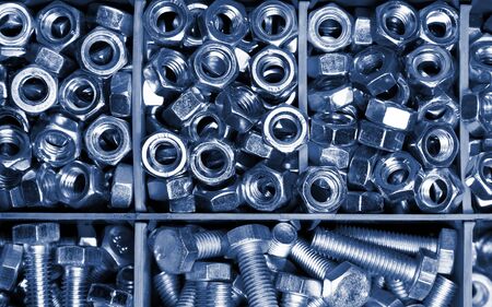 new bolts and nuts sorted in a container shot closeup, background, mechanic work concept, toning in classic blueの写真素材