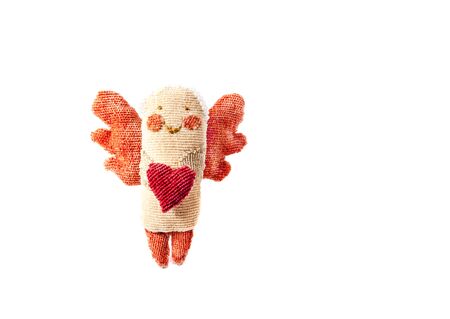 handmade figurine angel with wings holds in his hands a heart made of fabric isolated on a white...