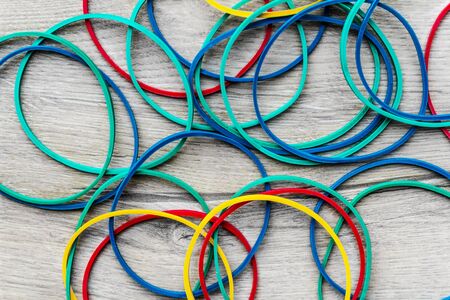 colored rubber bands on a light wooden texture flat layの写真素材