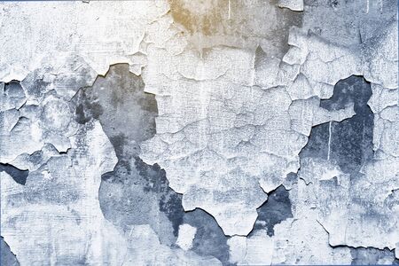 Closeup of old peeling classic blue trend color background texture of wallの写真素材