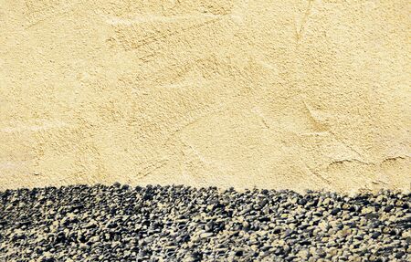 texture of beige sand plaster with sea pebbles, concept of summer background, vacation and recreation, page spread, background with copy spaceの写真素材