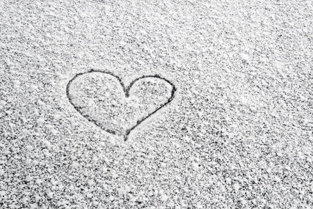 Heart painted on snow and there are and Many grains of white snow and snowflakes, February 14の写真素材