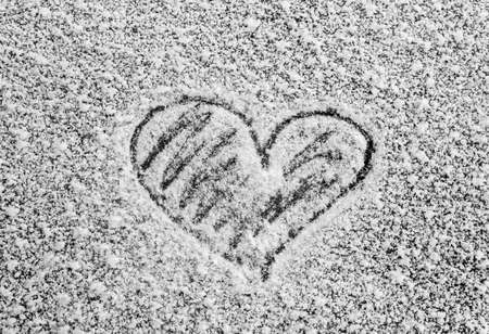 close-up heart scrawled on icy snow, frosty window, cold heart, card Valentine's dayの写真素材