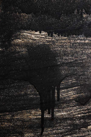 smudges of black paint on unpainted black metallic background with splashes of metallic sequins, repair concept, copy spaceの写真素材