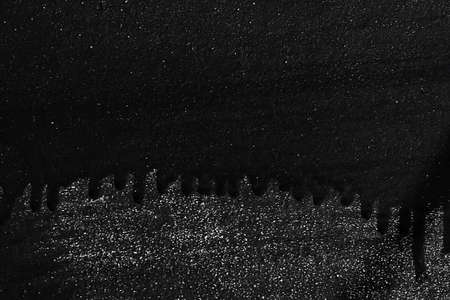 Black painted metal texture with smudges, scratches, traces of paintbrushes and gloss of undyed metal and splashes of gold sparkles. Copy space for textの写真素材