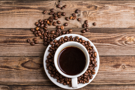 Coffee cup and coffee beans on wooden background. Top view.の写真素材