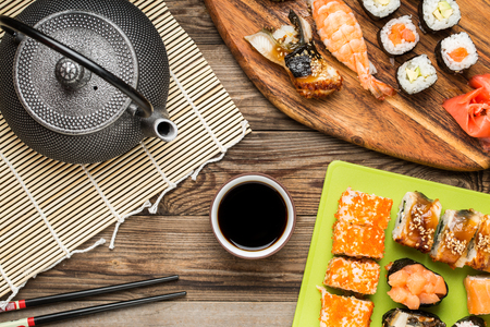 Asian food, sushi rolls, nigiri, maki with soy sauce on wooden backgroundの写真素材