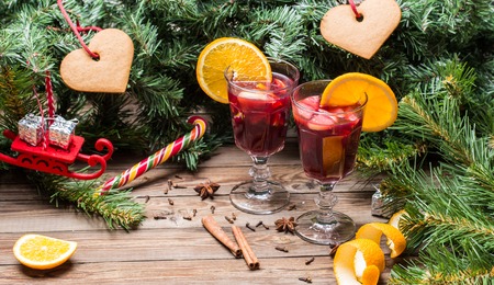Two glasses of hot mulled wine with oranges, apples and spices. Christmas background.の写真素材