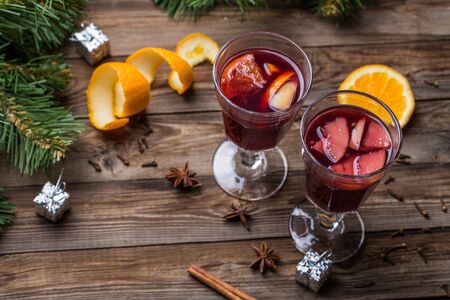 Two glasses of hot mulled wine with oranges, apples and spices. Christmas background.の写真素材
