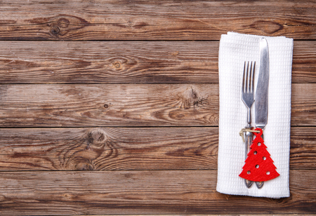 Christmas table place setting with fork and knife, decorated christmas toy - red fir-tree. Christmas holidays background.の写真素材