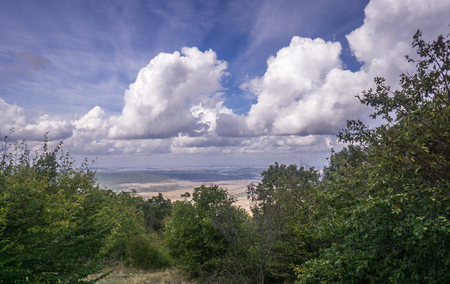 Scenic top view from the mountains, valley and forest on the background of sky and cloudsの写真素材