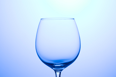 Empty glass for wine on blank blue backgroundの写真素材