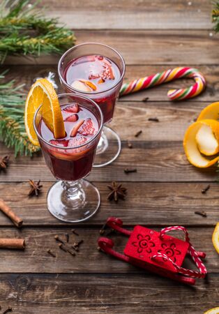 Two glasses of hot mulled wine with oranges, apples and spices. Christmas background.の写真素材