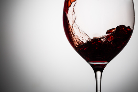 Red wine splashing in glass, beautiful image of an alcoholic beverage closeupの写真素材