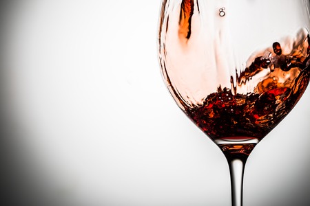 Transparent glass on blank gray background with red wineの写真素材