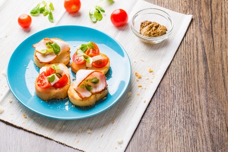 Traditional Italian antipasti bruschetta with tomato, cheese and bacon.の写真素材