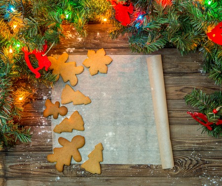 Ginger cookies on parchment paper on festive wooden tableの写真素材