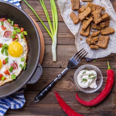 Fred eggs in pan with tomatoes and green fresh onion.の写真素材