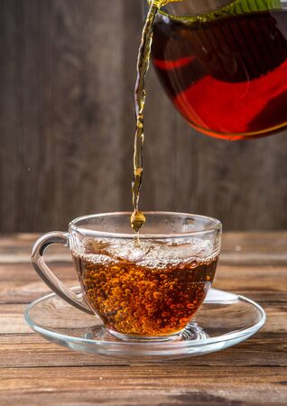 Black tea poured from teapotの写真素材