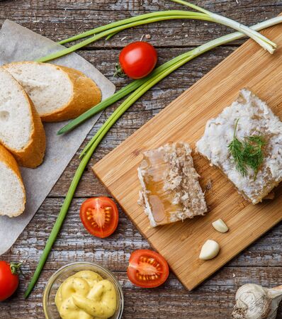 Homemade jelly meat with mustard, bread, tomatoes and garlic on the table. Holodetsの写真素材