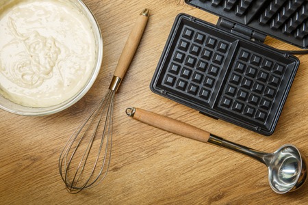 Making waffles at home - waffle iron and batter in bowlの写真素材