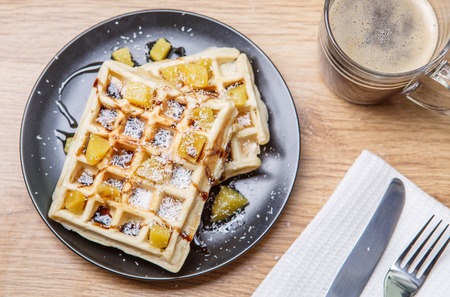 Black plate with homemade waffles, tangerines, chocolateの写真素材