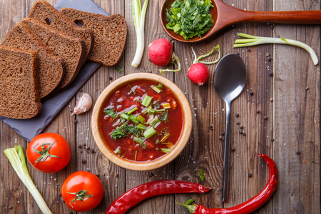 Beet soup in wooden plate with vegetablesの写真素材