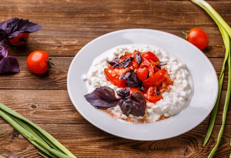 Salad with cottage cheese and tomatoes on wood table.の写真素材