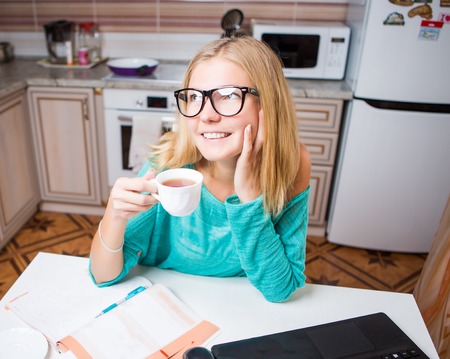 Woman with cup in kitchenの写真素材