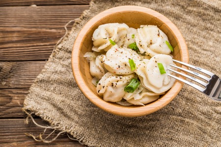 Meat dumplings - russian pelmeni, ravioli with meat on a wooden plateの写真素材