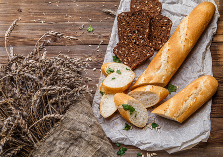 Fresh bread on table with sunflower seeds and wheatの写真素材