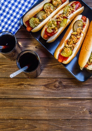 American hot dog with pickles,onions, ketchup, mustard and two sodaの写真素材
