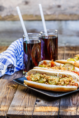 American hot dog with pickles,onions, ketchup, mustard and two sodaの写真素材
