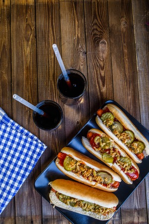 American hot dog with pickles,onions, ketchup, mustard and two sodaの写真素材