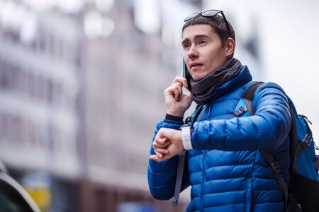 Man talking on phone and looking at smartwatchの写真素材