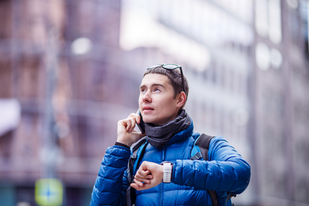 Man talking on phone and looking at smartwatchの写真素材