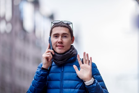 Man talking on phone and waving his handの写真素材
