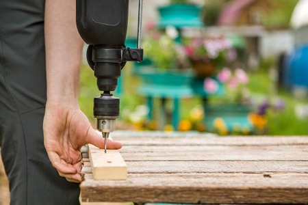 Worker fastens board with drillの写真素材