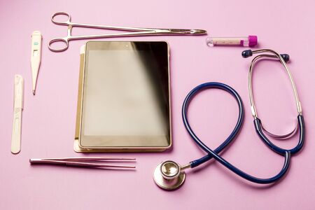 Tablet pc and doctor tools on blue surfaceの写真素材