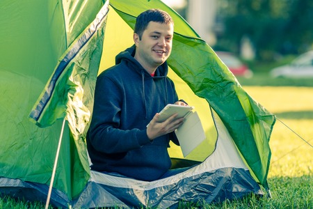 Man is sitting in a tent with a tabletの写真素材